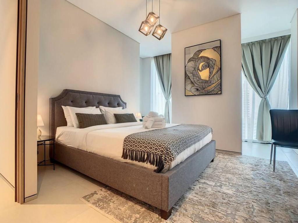 a bedroom with a large bed and a chair at Key View - Address JBR in Dubai