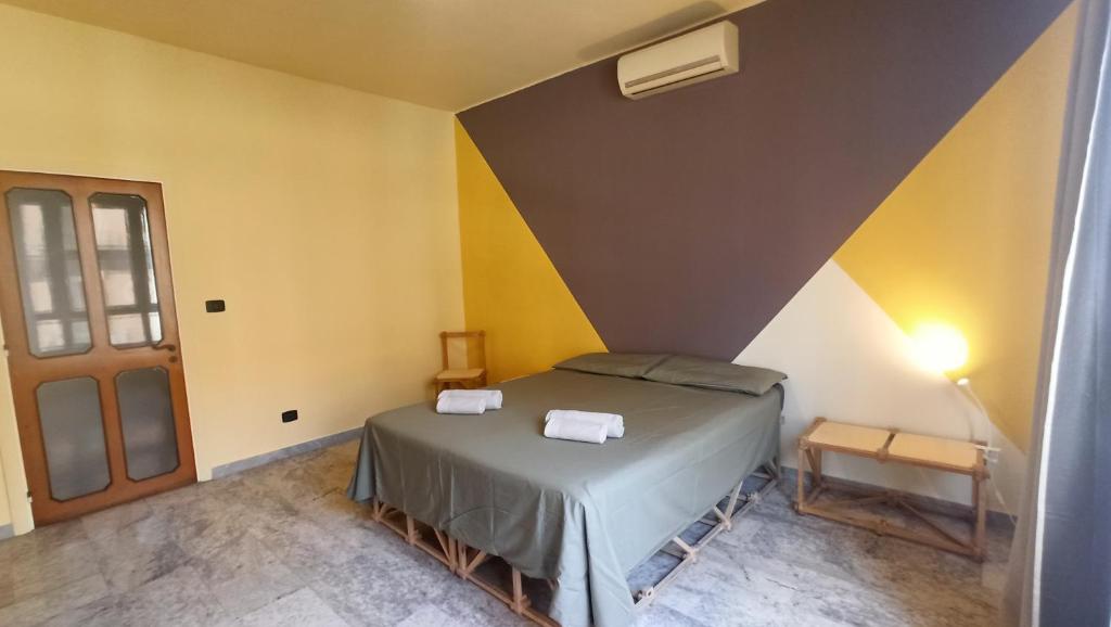 um quarto com uma cama num quarto com paredes amarelas em Casa Base em Bari