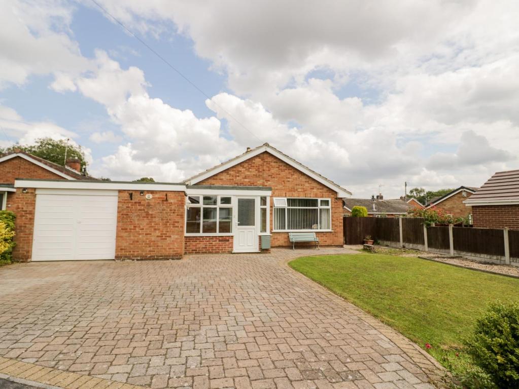 a brick house with a white garage at Lynsted Lodge in Ashby de la Zouch