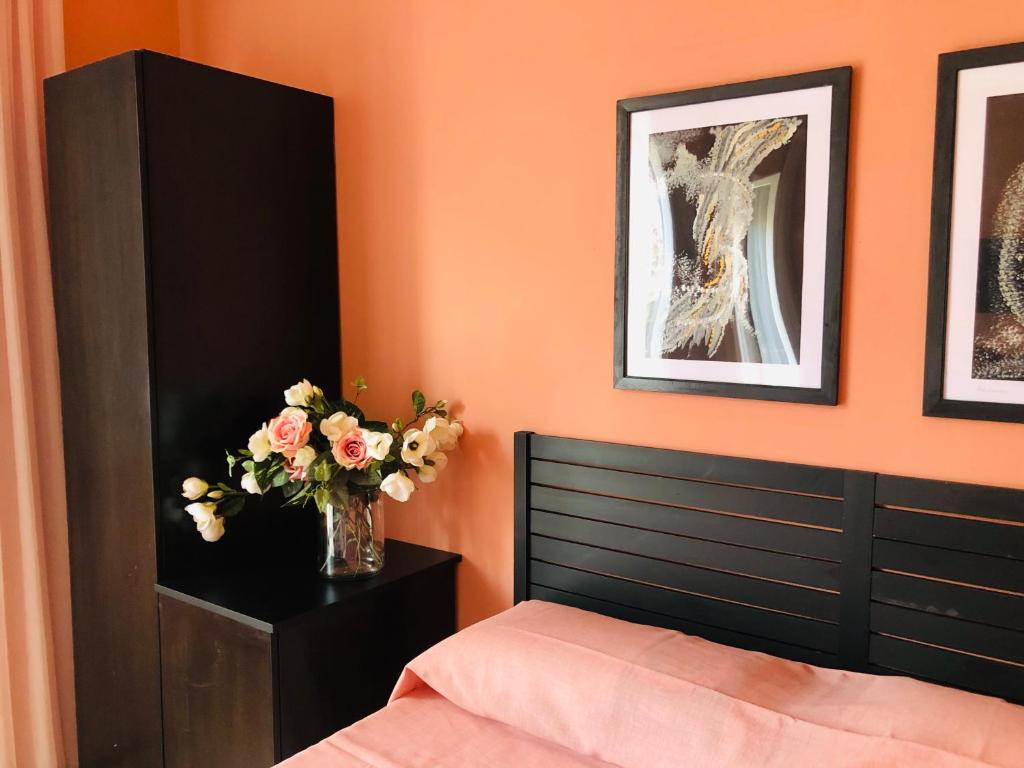 sypialnia z łóżkiem i wazonem kwiatów w obiekcie Lo Studio del Pittore w mieście Vasto
