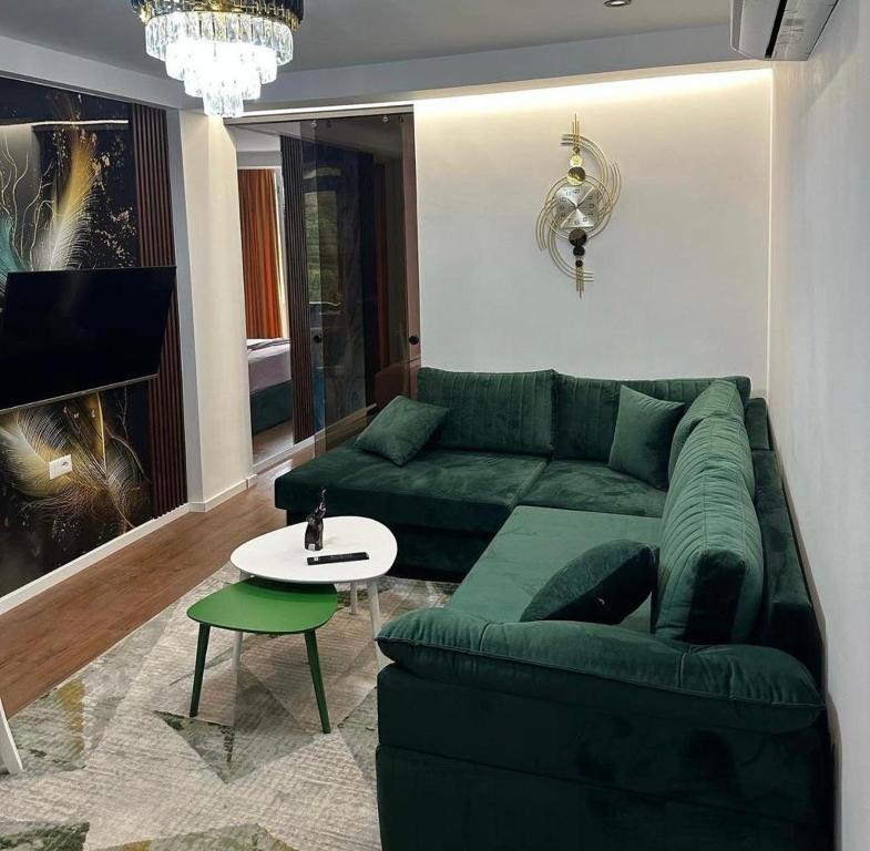 - un salon avec un canapé vert et une table dans l'établissement Holiday apartaments, à Tirana