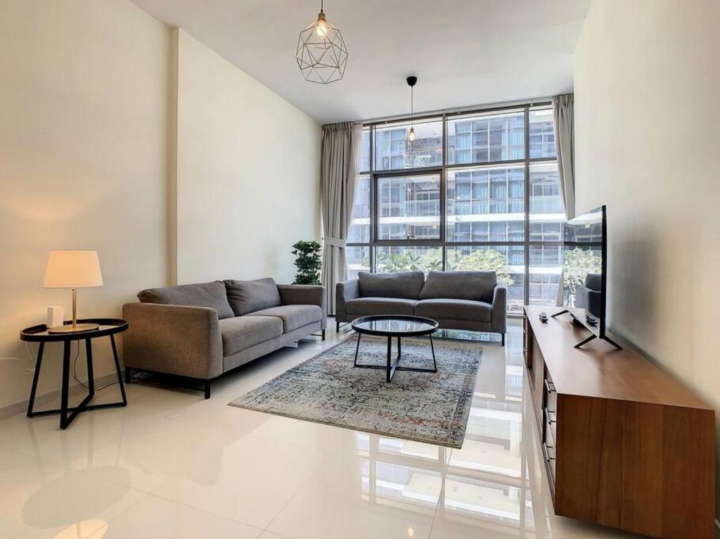 a living room with a couch and a tv at Key View - Loreto 3B, Damac Hills in Dubai Marina
