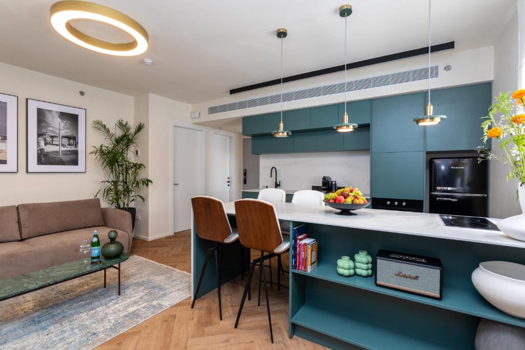 een keuken en een woonkamer met een bank en een tafel bij De Sheinkin in Tel Aviv