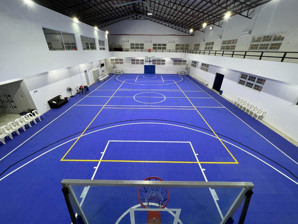 un grand court de tennis avec un sol bleu dans l'établissement Villa Del Cascel, à Bulala