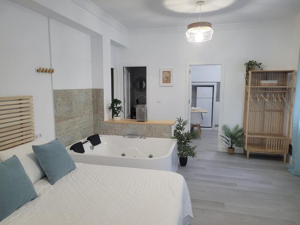 um quarto com uma cama e uma banheira em APARTAMENTO LOFT DELUXE INTERIOR Y EXTERIOR em El Bosque