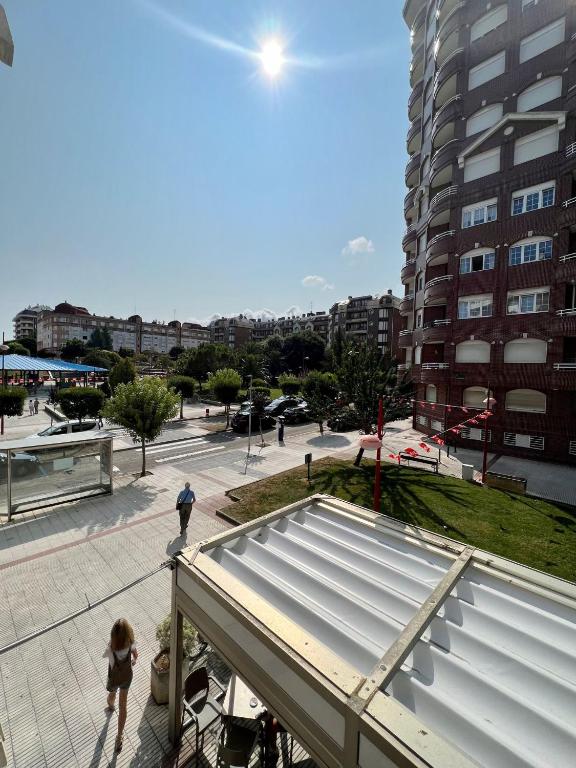 twee mensen lopen op een stoep in de buurt van een gebouw bij Apto Anita 5 ' playa Brazomar in Castro-Urdiales