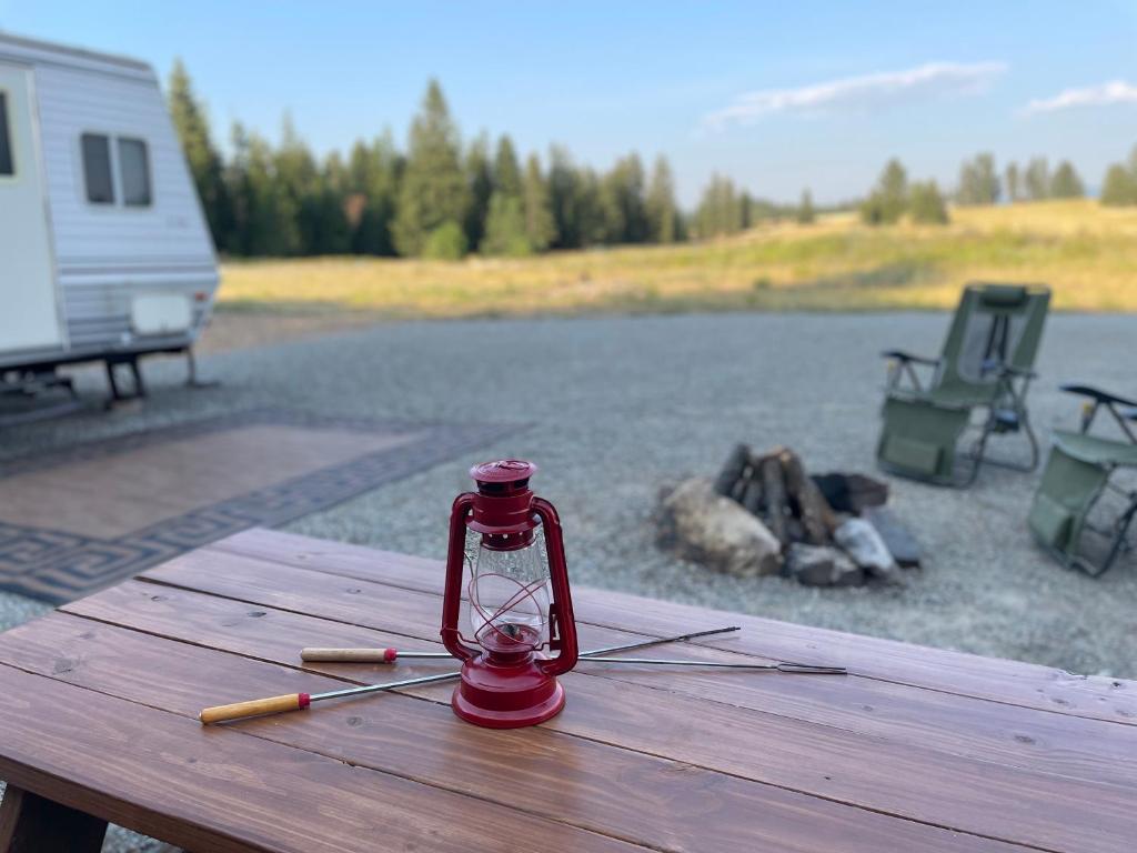 una lanterna rossa seduta su un tavolo da picnic accanto a un lago di Quiet Country Rimrock Retreat a Hayden