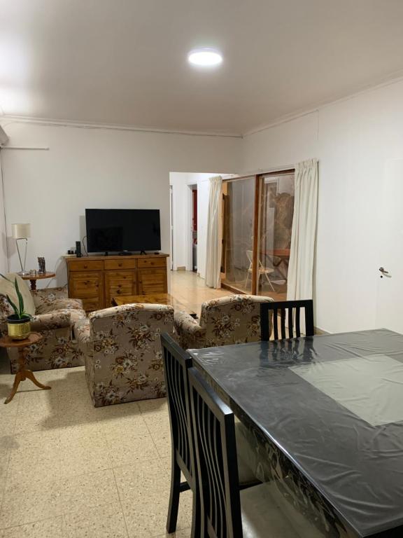 sala de estar con mesa con sillas y TV en Departamento Las Heras en Mendoza