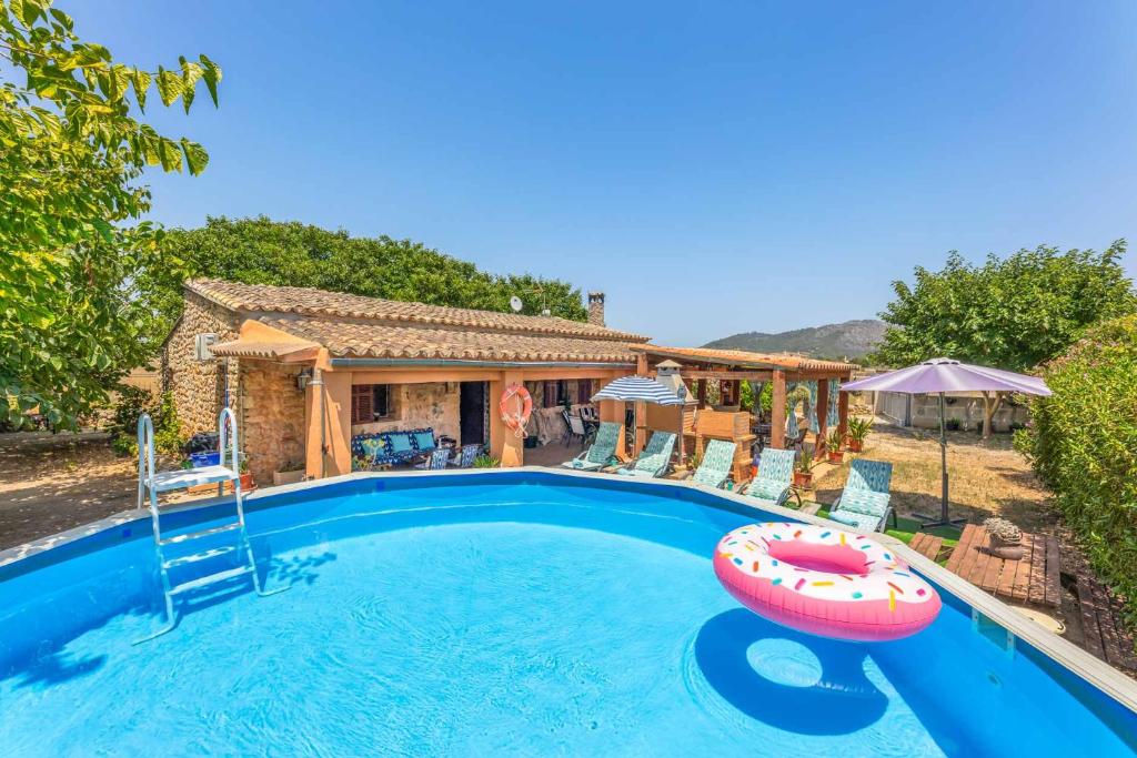 una piscina con una balsa inflable frente a una casa en YupiHome Finca Can Calistro, en Inca