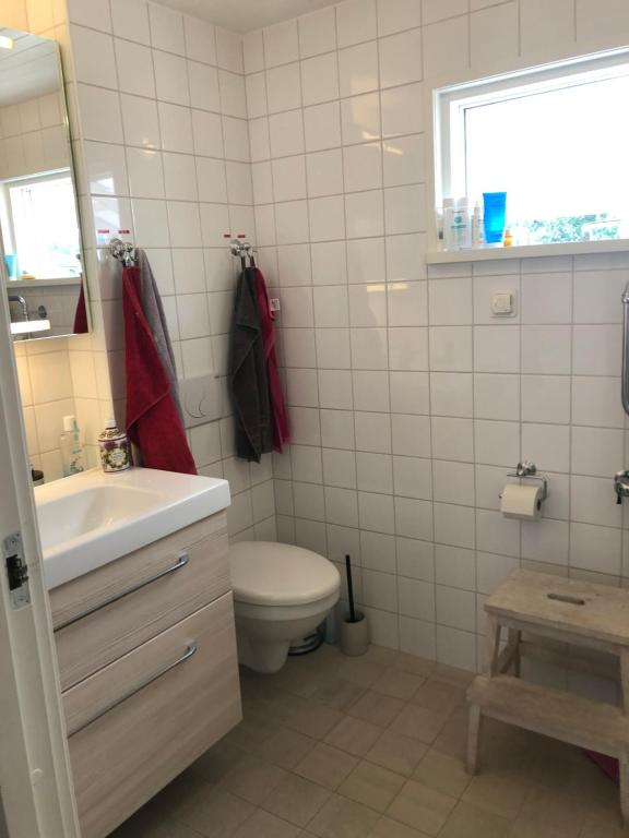 a bathroom with a toilet and a sink and a window at Havsnära villa, närhet till stan in Värmdö