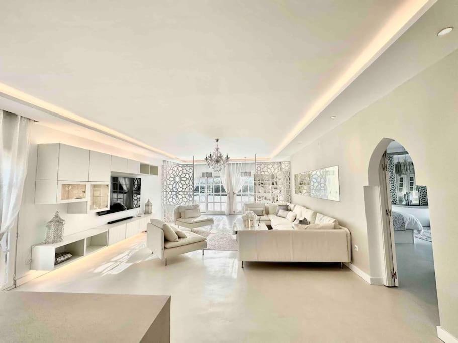 uma ampla sala de estar branca com um sofá e cadeiras em Mil y un momentos mágicos: Villa con encanto árabe em Marbella