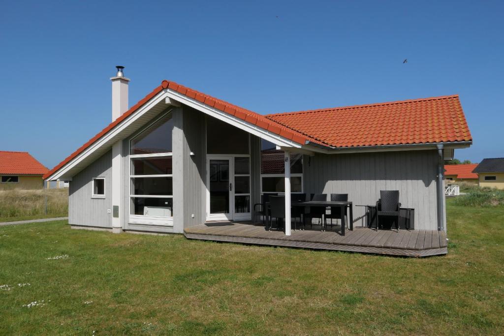 a house with a deck with a table and chairs at Resort 2 Sea Lodge C 51 in Großenbrode