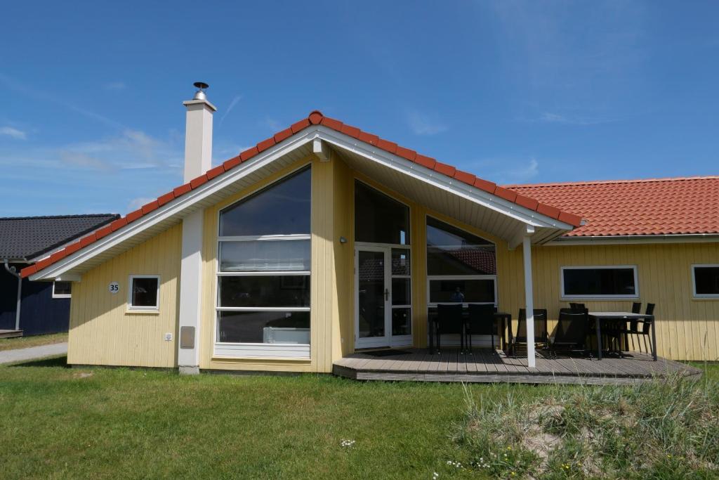 uma casa com uma grande porta de vidro e um pátio em Resort 2 Ferienhaus Typ D 35 em Grossenbrode