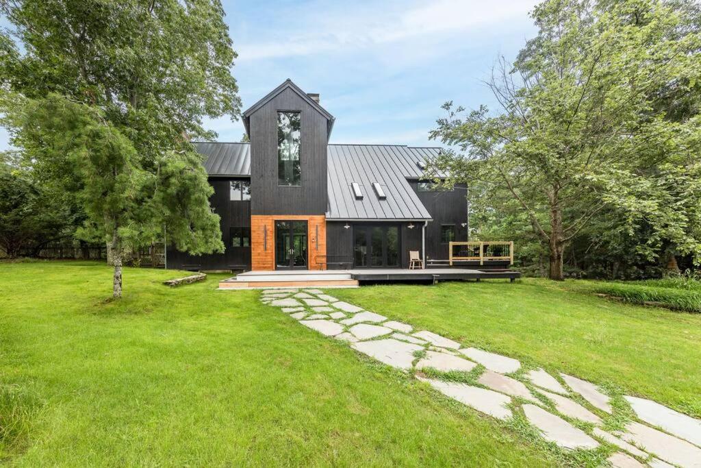 een huis met een zwart dak en een grasveld bij Artisan Grove Four bedrooms 3 bathrooms with Pool, Equipped Kitchen and Laundry in East Hampton