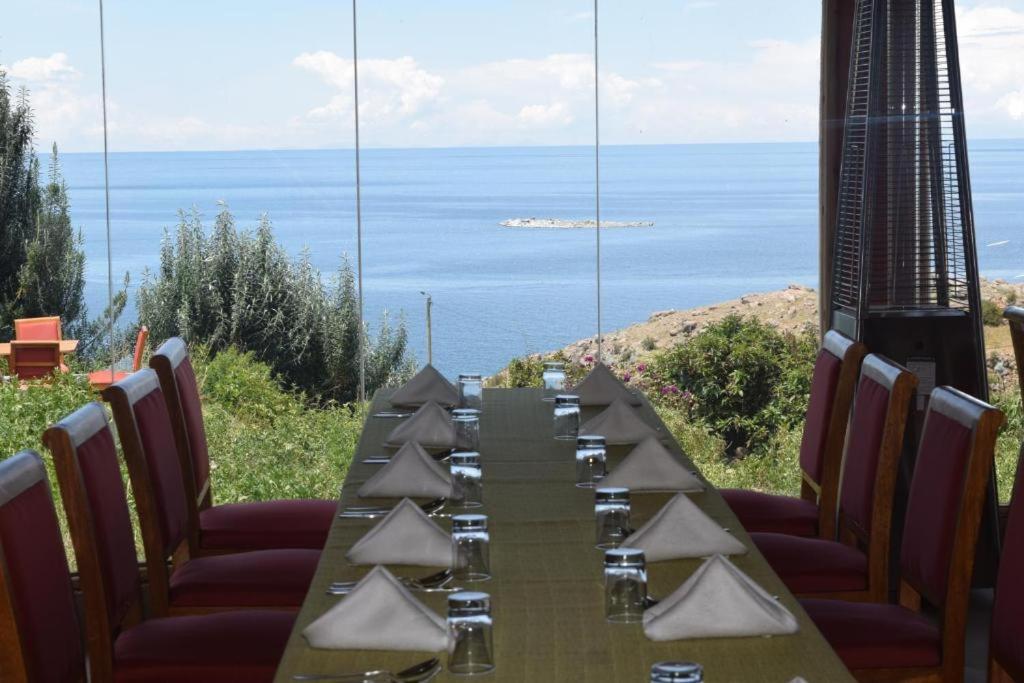 a long dining table with a view of the ocean at Allpa Tika Lodge in Amantani