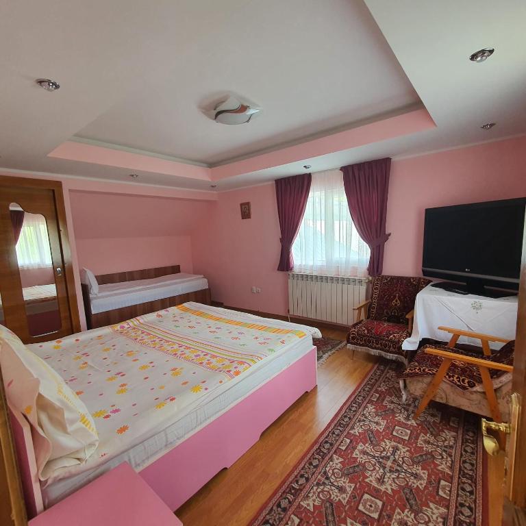 a bedroom with a large bed and a flat screen tv at Apartament 3 camere strada Bailor Baltatesti in Bălţăteşti