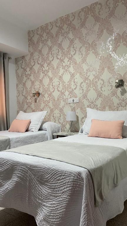 two beds with pink pillows in a bedroom at Rincón Extremeño in Plasencia
