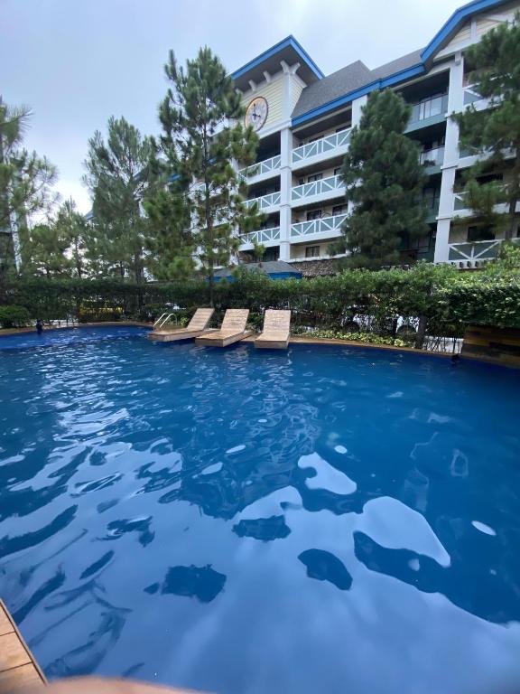 a swimming pool with sharks in the water in front of a hotel at Alitheia Condo @ Pine Suites Tagaytay in Tagaytay