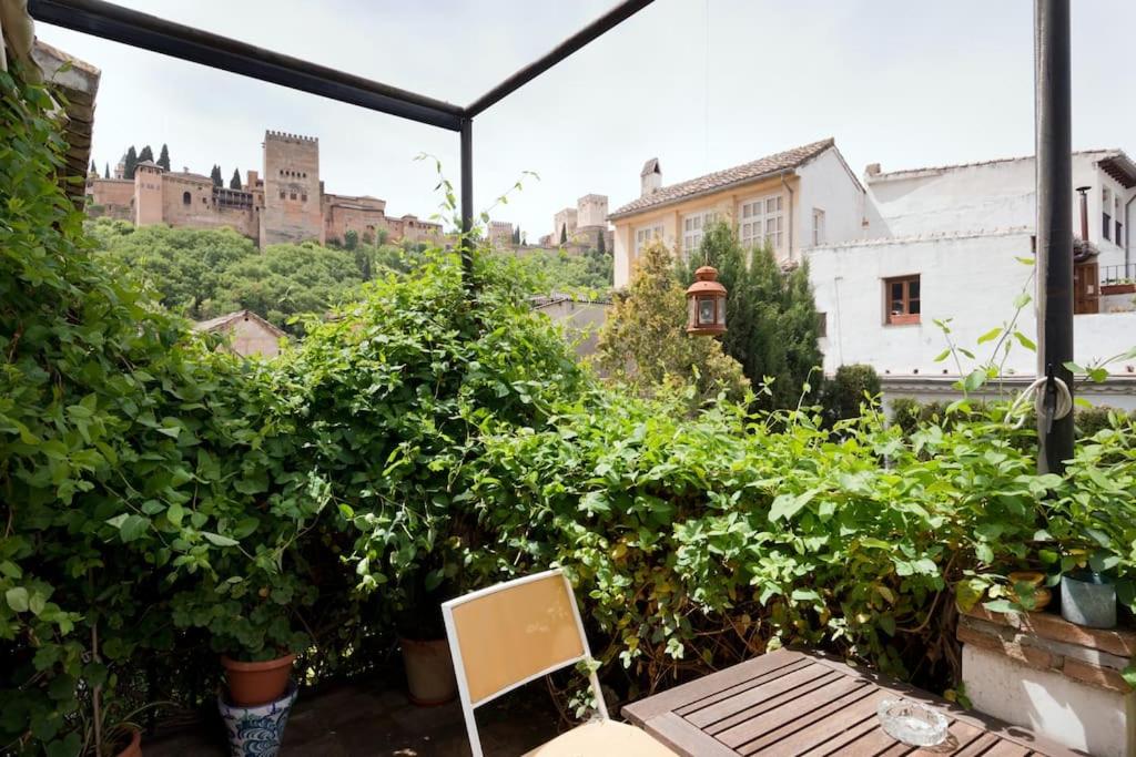 a patio with plants and a chair and a building at Apartamento Oasis Granada in Granada