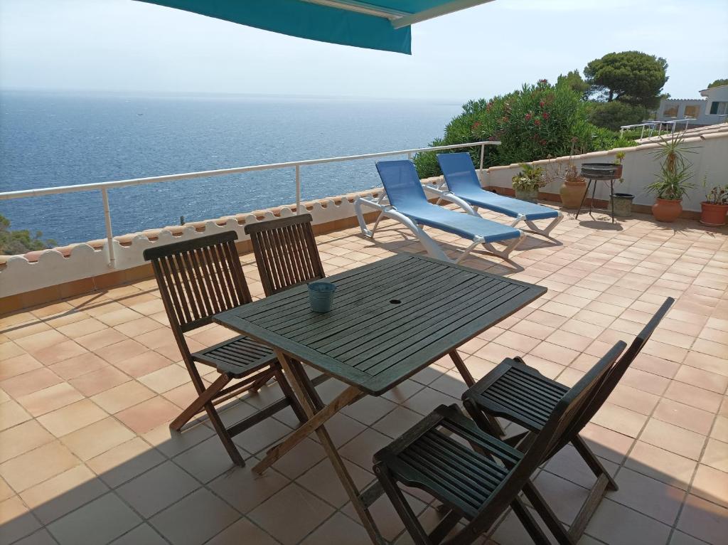 a table and chairs on a patio with the ocean at "La Terrasse de la mer 8" -Climatisation-Wifi-BBQ -Piscine-Parking in Begur