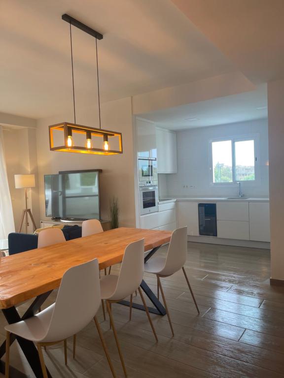 een keuken en eetkamer met een houten tafel en stoelen bij Anpartamento con Encanto Costa Ballena in Costa Ballena