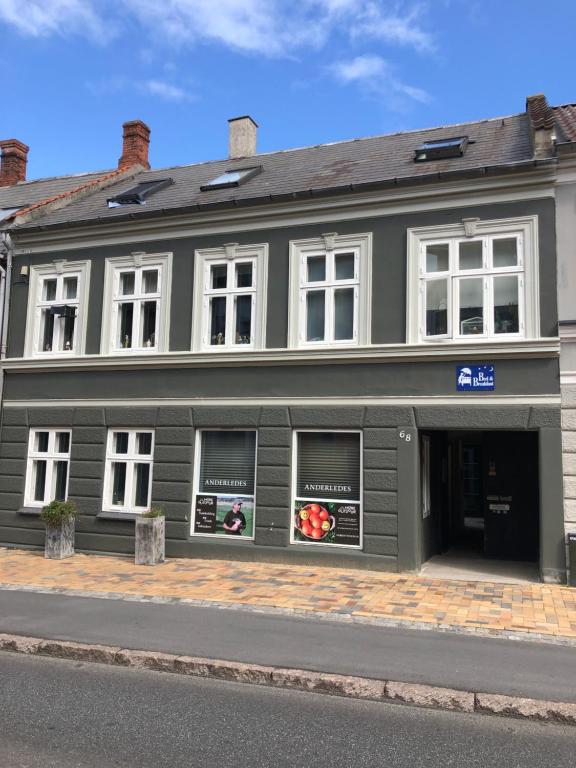 un edificio negro con ventanas en una calle en Hus-lejlighed i ejendommens baghus, en Odense