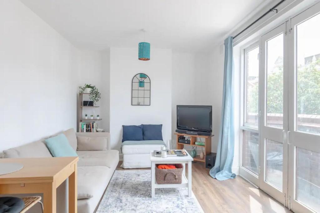 a living room with a couch and a tv at Bright & Calming 1BD Flat - Islington in London