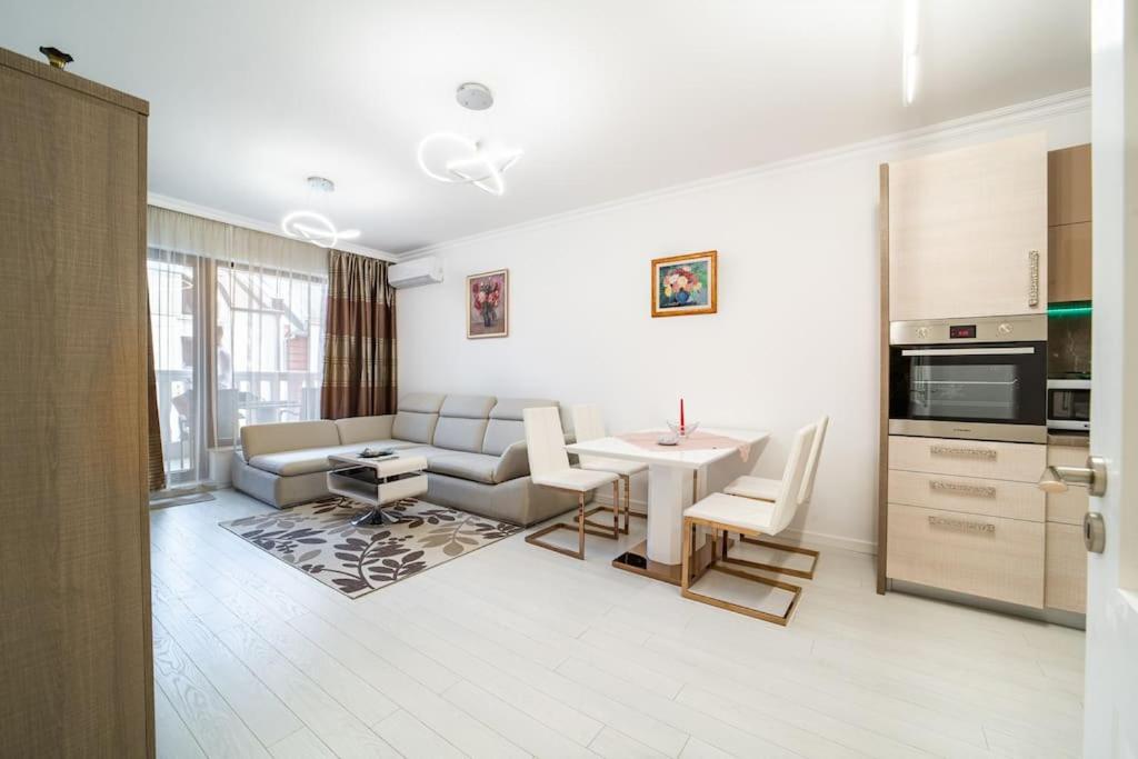 Il comprend une cuisine et un salon avec une table et un canapé. dans l'établissement Grand Karavel Top Center Lux Apartment, à Varna
