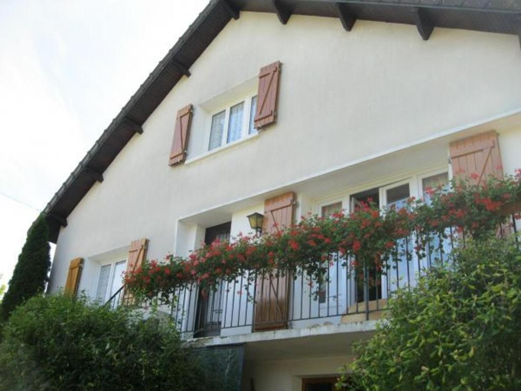 Cousancelles的住宿－Guestroom Cousances-les-Forges, 1 pièce, 2 personnes - FR-1-585-123，白色的建筑,阳台上装有红色的鲜花