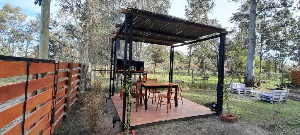 a wooden pergola with a table and chairs in a yard at EL DESPERTAR in Nueva Palmira