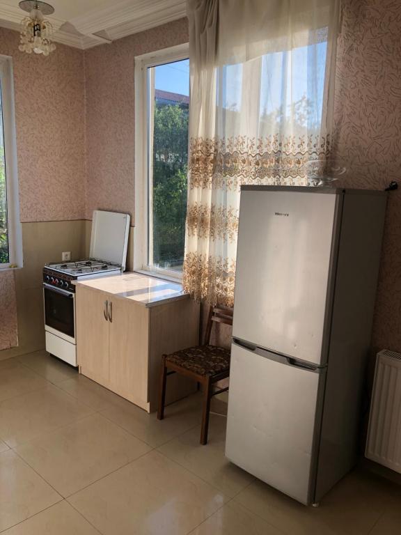 uma cozinha com um frigorífico branco e uma janela em bakuriani home em Bakuriani