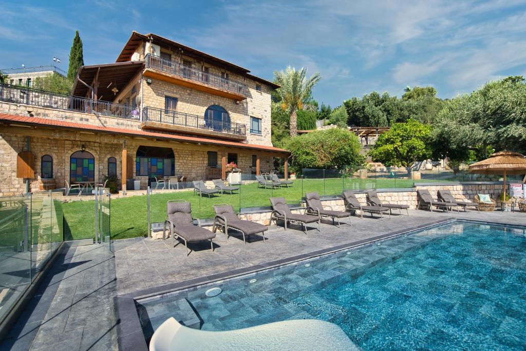 a house with a swimming pool next to a building at Hameiri Estate in Rosh Pinna