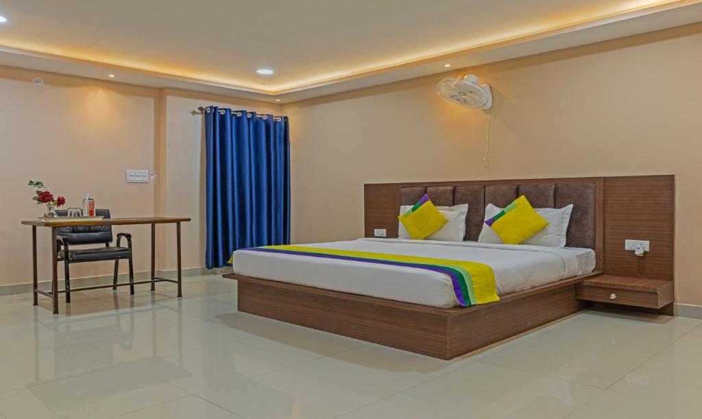 a bedroom with a bed and a table and a desk at Itsy By Treebo - Kashi Grand, BHU in Varanasi