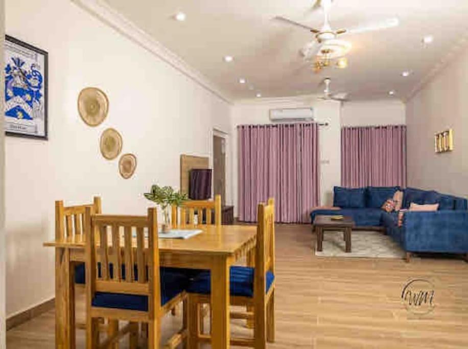 sala de estar con mesa y sofá azul en WellingManor Apartments - Luxury, en Accra