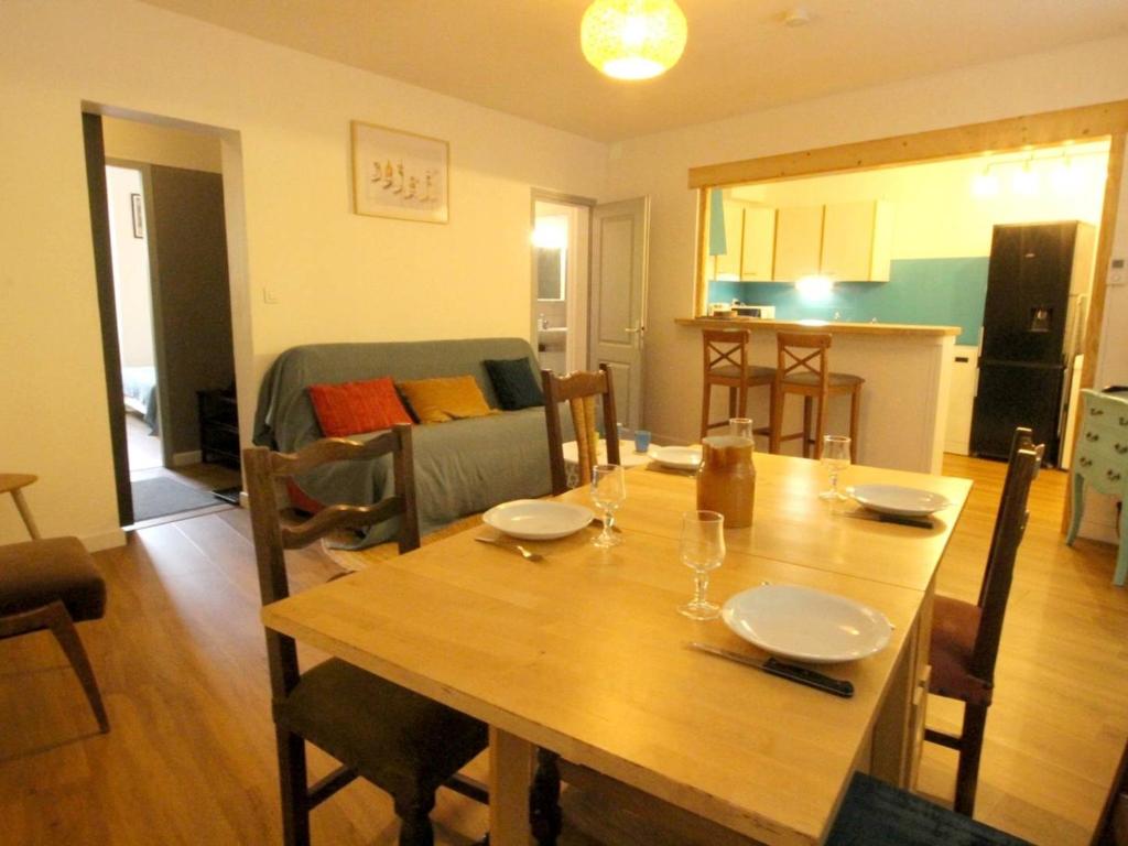 un salon avec une table en bois et une cuisine dans l'établissement Appartement tout confort 3 pièces avec terrasse et wifi, face aux Thermes de Luchon - FR-1-313-225, à Luchon
