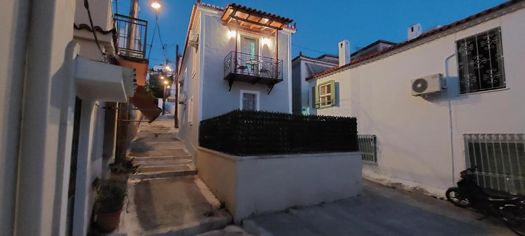 un callejón con un edificio blanco con balcón en Coco Luxury Apartments, en Poros