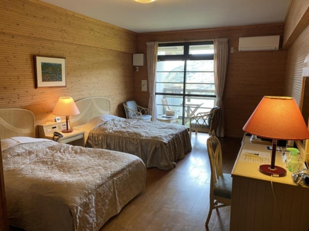 Habitación de hotel con 2 camas y escritorio con lámpara. en Hotel Bellreef Otsuki - Vacation STAY 43762v, en Otsuki