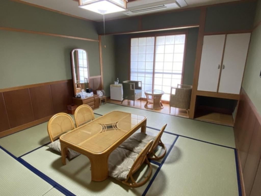um quarto com uma mesa e cadeiras e um espelho em Hotel Bellreef Otsuki - Vacation STAY 43750v em Otsuki