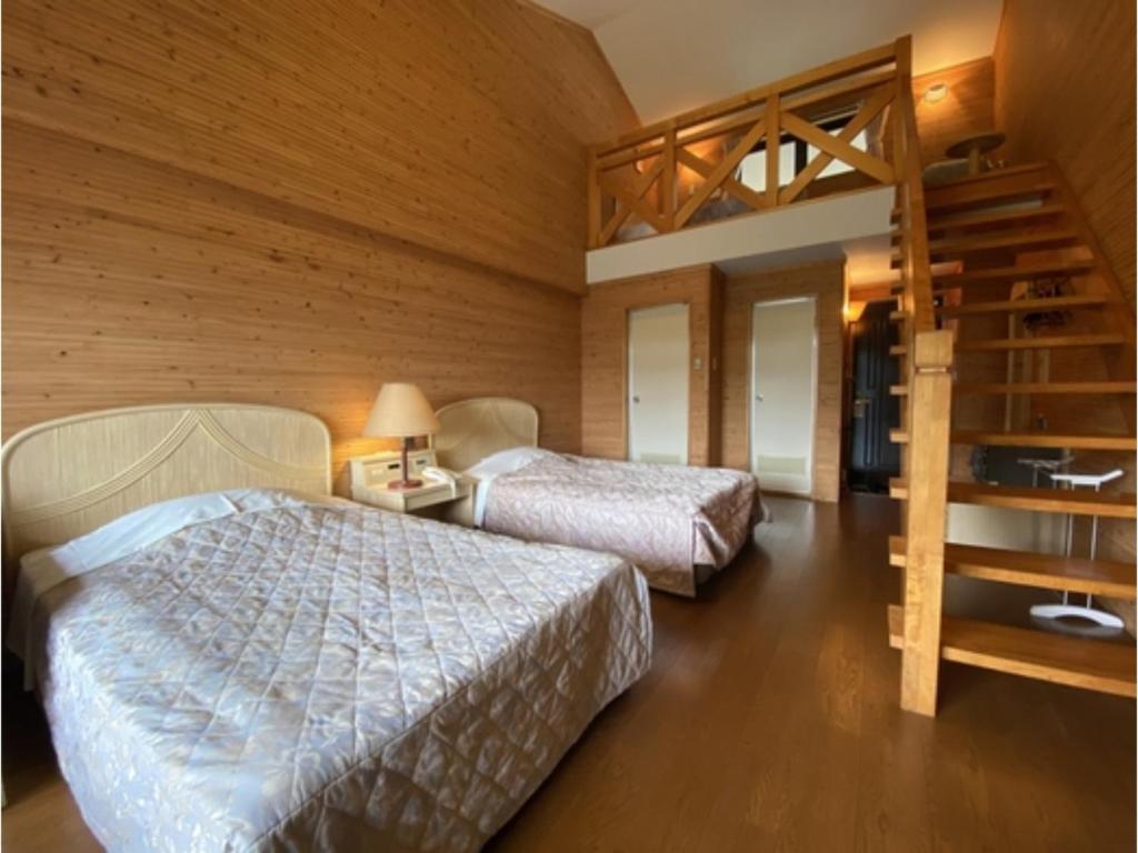 una camera con 2 letti e una parete in legno di Hotel Bellreef Otsuki - Vacation STAY 43767v a Otsuki