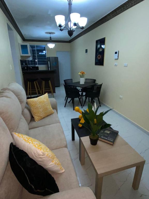 uma sala de estar com um sofá e uma mesa em Acogedor Apartamento em Santiago de los Caballeros