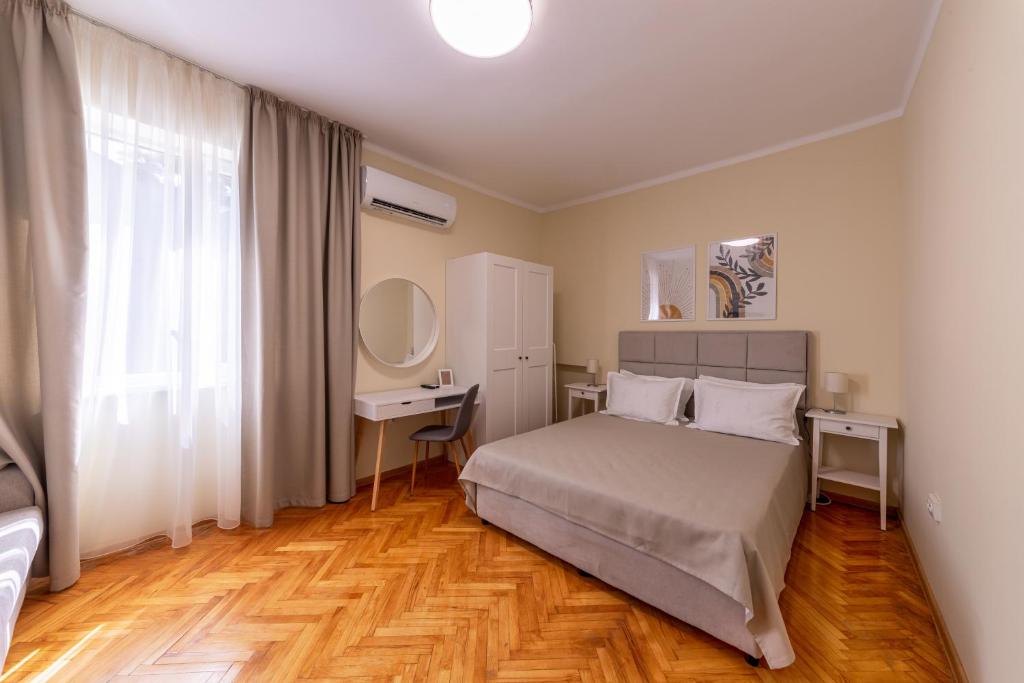 a bedroom with a bed and a desk and a window at Perfect Spot Apartment in Varna City