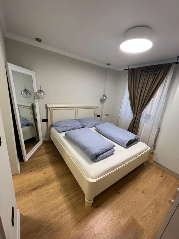 a bedroom with a bed with blue pillows and a mirror at Kalim’s apartment in Arad