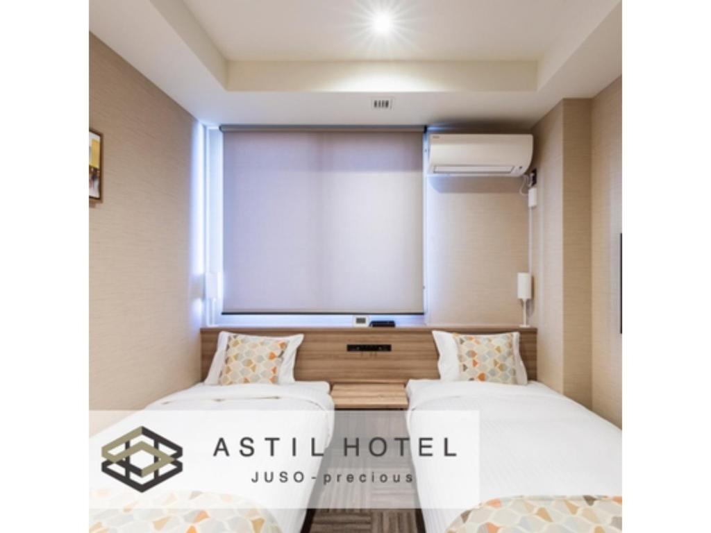 two beds in a hotel room with a projection screen at Astil Hotel Juso Precious - Vacation STAY 16039v in Osaka