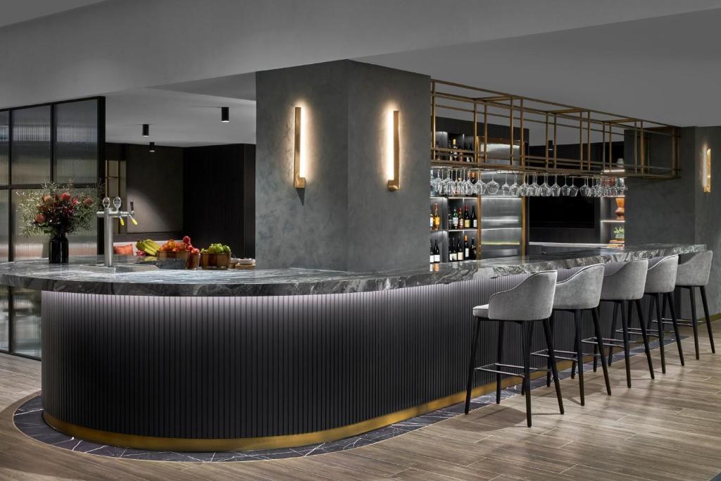 a bar in a restaurant with stools at Melbourne Marriott Hotel in Melbourne
