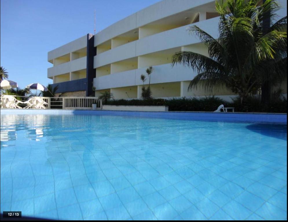 a large swimming pool in front of a building at MB Pousada SOL in Conde