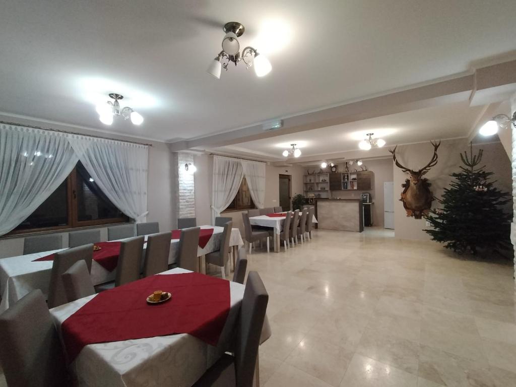 a dining room with a red table and chairs at Casa Vânătorilor in Arieşeni