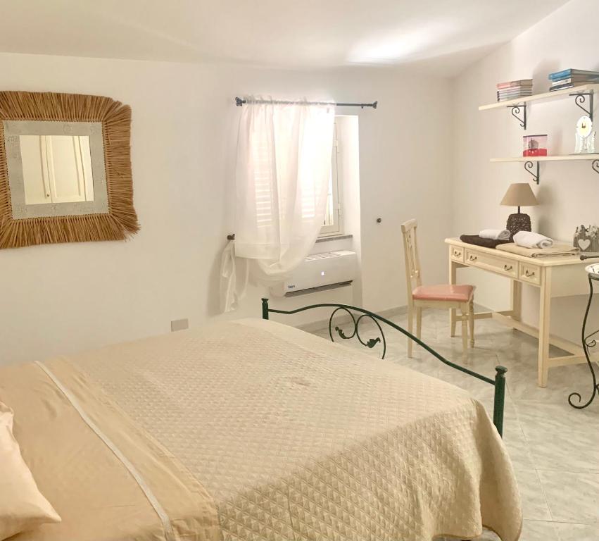 1 dormitorio con cama, escritorio y espejo en Da Angela en Orgosolo