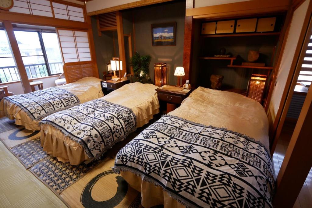 um quarto com três camas num quarto em Natural Mind Tour guest house - Vacation STAY 23273v em Sado