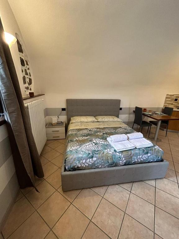 a bedroom with a bed and a table and a tableablish at CASA VACANZA PIEVE in Pisogne