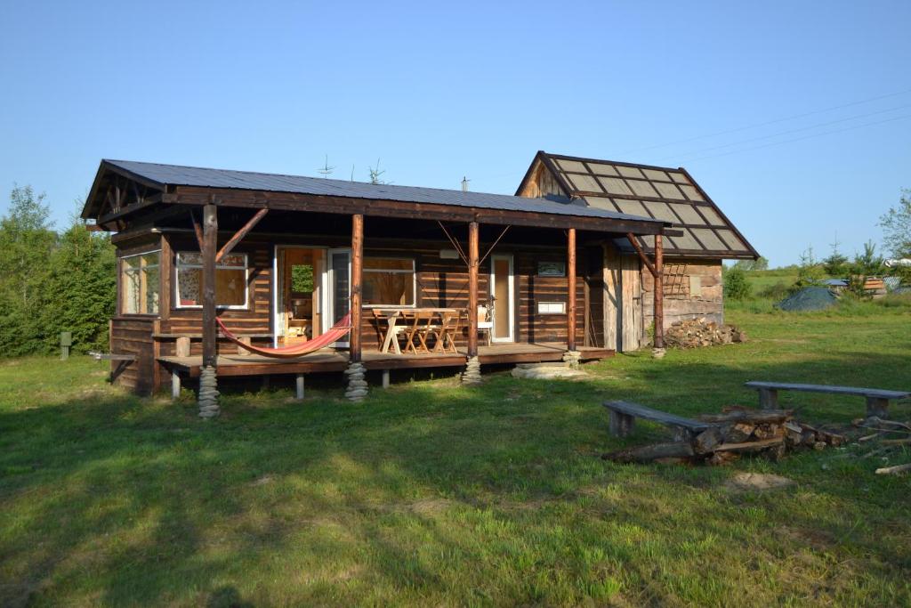 Cabaña de madera con hamaca en el patio en bieszczadzki holender, en Lipie